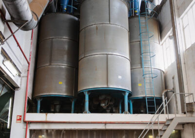 Em Santa Maria da Feira, Humberto Barbosa capta silos industriais e trabalhador junto a bancada em fotografia industrial