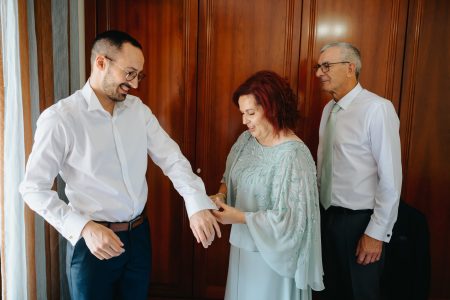Noivo ajusta os botões de punho com ajuda da mãe antes da cerimónia, fotografia de casamento por Humberto Barbosa em Santa Maria da Feira