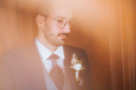 Noivo de fato escuro e boutonnière aguarda com serenidade, fotografia de casamento por Humberto Barbosa em Santa Maria da Feira