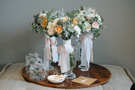 Bouquets de noiva com rosas e eucalipto sobre mesa de madeira, fotografia de casamento por Humberto Barbosa em Santa Maria da Feira