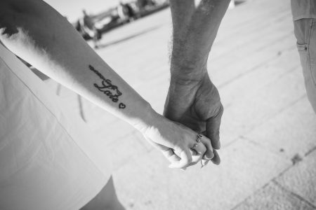 Mãos entrelaçadas selam a promessa de amor eterno, tatuagem a revelar cumplicidade — fotógrafo de casamento Santa Maria da Feira, Humberto Barbosa Fotografia