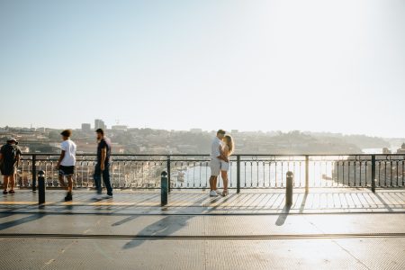Casal apaixonado abraçado na Ponte D. Luís I ao pôr do sol, momento de cumplicidade captado por Humberto Barbosa, fotógrafo de casamento Porto