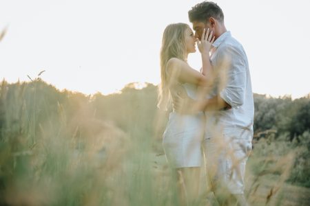 Carícia suave entre noivos num campo dourado ao pôr do sol, cumplicidade captada por Humberto Barbosa, fotógrafo de casamento Porto