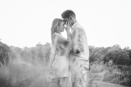 Momento íntimo entre os noivos num campo ao pôr do sol, capturado por Humberto Barbosa, fotógrafo de casamento em Santa Maria da Feira