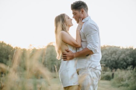 Olhar apaixonado entre noivos ao pôr do sol num campo dourado, momento de cumplicidade captado por Humberto Barbosa, fotógrafo de casamento Porto