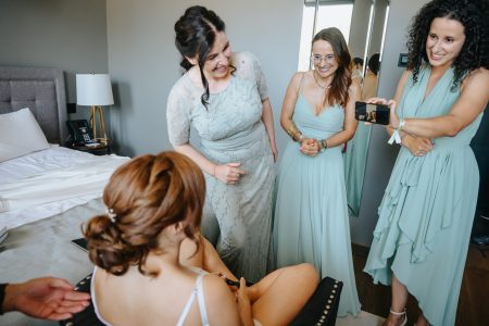 No quarto de hotel em Santa Maria da Feira, amigas observam a noiva com alegria antes da cerimónia, fotografia de casamento por Humberto Barbosa