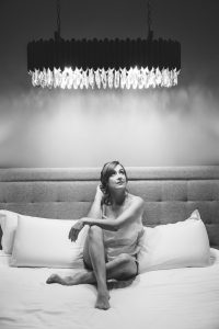 Noiva descansa na cama sob luz suave em registo intimista de Humberto Barbosa, fotógrafo de casamento em Santa Maria da Feira