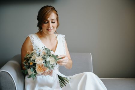 Noiva admira o ramo de flores em momento sereno captado por Humberto Barbosa, fotógrafo de casamento em Santa Maria da Feira