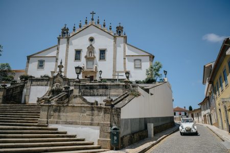 Carro decorado estacionado junto a escadaria de igreja, fotografia de casamento por Humberto Barbosa em Santa Maria da Feira