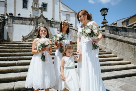 Damas de honor com ramos aguardam no adro da igreja captadas por Humberto Barbosa, fotógrafo de casamento em Santa Maria da Feira