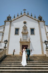 Noivos sobem escadaria rumo à igreja em dia de casamento captado por Humberto Barbosa em Santa Maria da Feira