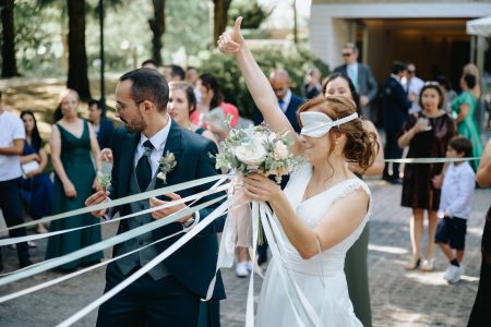 Noiva de olhos vendados celebra com bouquet e gesto triunfante, fotografia de casamento por Humberto Barbosa em Santa Maria da Feira