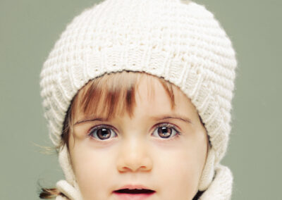 Em São João da Madeira, Humberto Barbosa capta criança de olhos claros com gorro branco — fotografia newborn e infantil