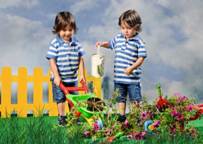 Gémeos a regar plantas em cenário lúdico captados por Humberto Barbosa em São João da Madeira — fotografia infantil criativa