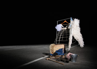 Arara de vestuário teatral sobre estrada à noite captada por Humberto Barbosa em Santa Maria da Feira — fotografia criativa de moda