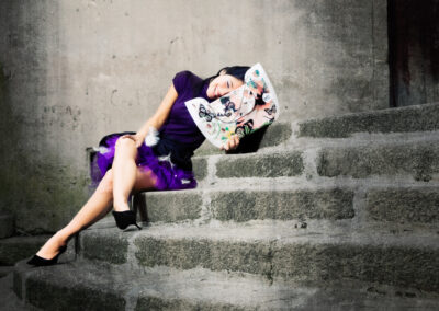 Em Santa Maria da Feira, Humberto Barbosa capta pose reclinada em vestido roxo sobre degraus — fotografia de moda criativa