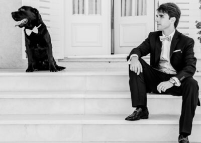 Em escadaria branca, noivo e cão de gravata aguardam serenamente — Humberto Barbosa capta fotografia de casamento em Espinho