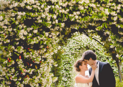 Casal beija-se sob arco de flores brancas — Humberto Barbosa capta fotografia de casamento em Santa Maria da Feira
