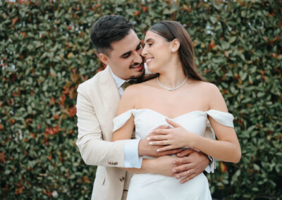Andreia e Roberto num abraço cheio de ternura junto à parede de flores, cumplicidade genuína entre os noivos, momento intímo e repleto de afeto, Humberto Barbosa Fotografia Santa Maria da Feira